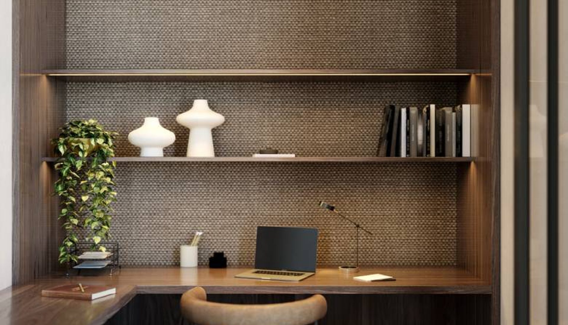 Home office alcove with dark wood shelves, a laptop on the desk, a beige chair, and a trailing plant against a textured backsplash.