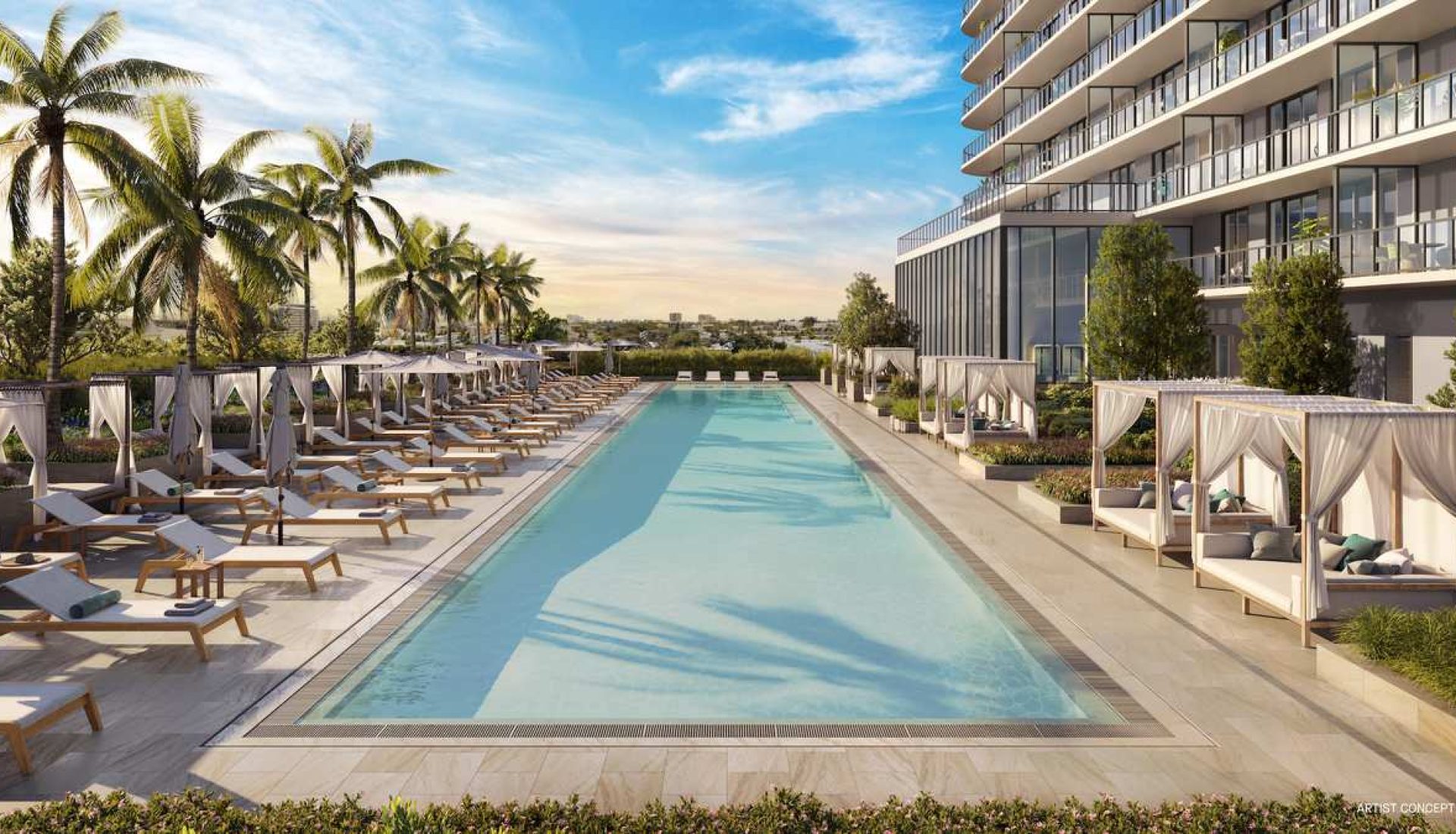 Luxurious hotel pool area with palm trees, cabanas, and sun loungers along a long rectangular pool at sunset.