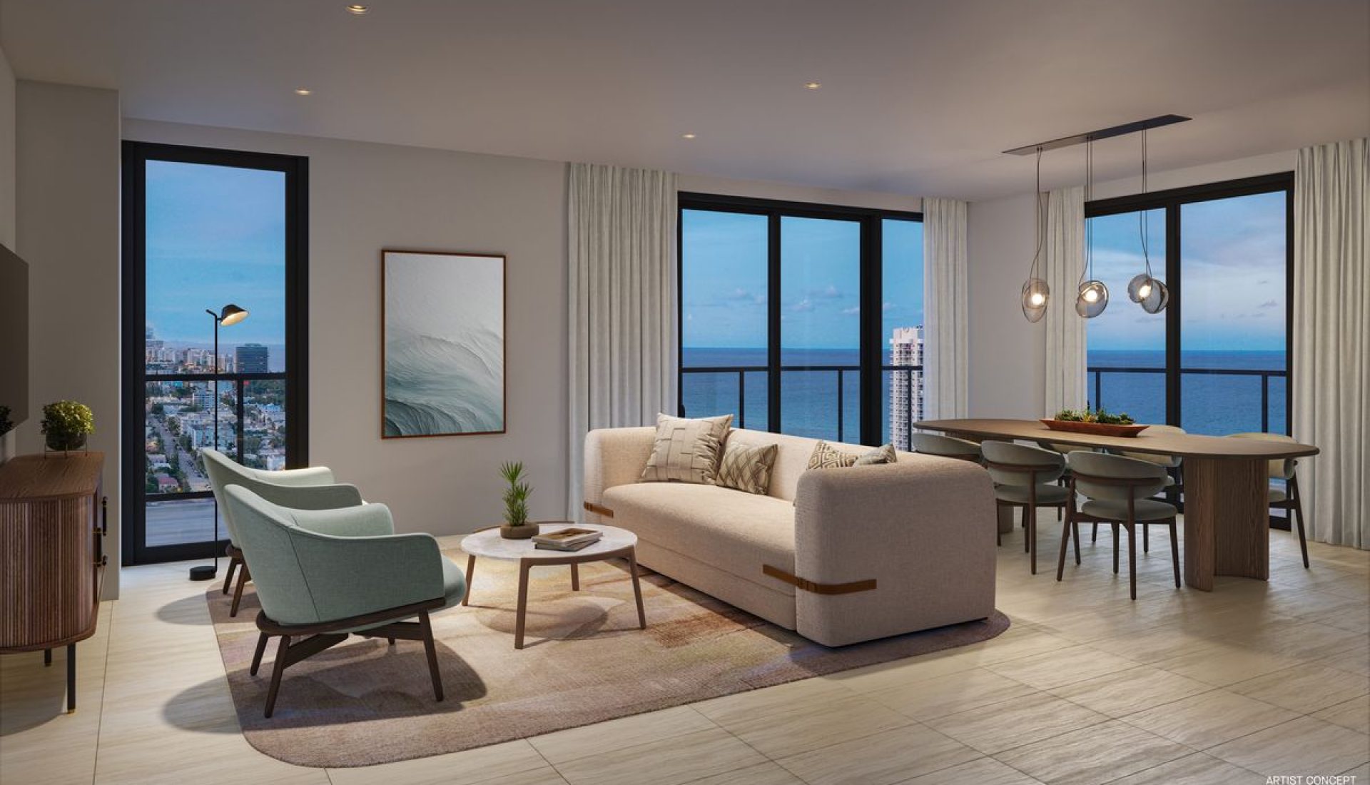 Modern living room with beige sofa, two teal chairs, and a round coffee table, set on a neutral rug with large windows showing blue ocean view and cityscape beyond.