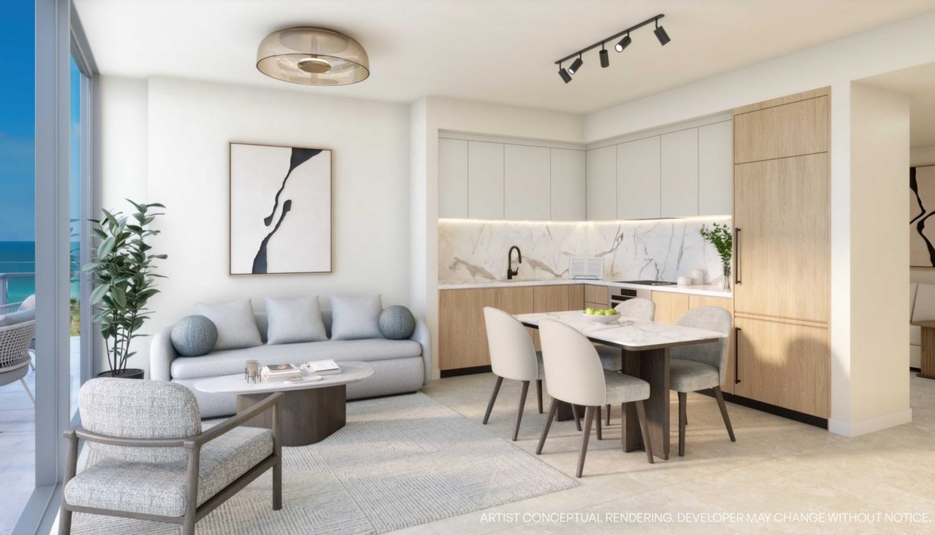 Open-plan living area with a gray sofa, round coffee table, dining table, marble backsplash, and a sea view through a sliding glass door.