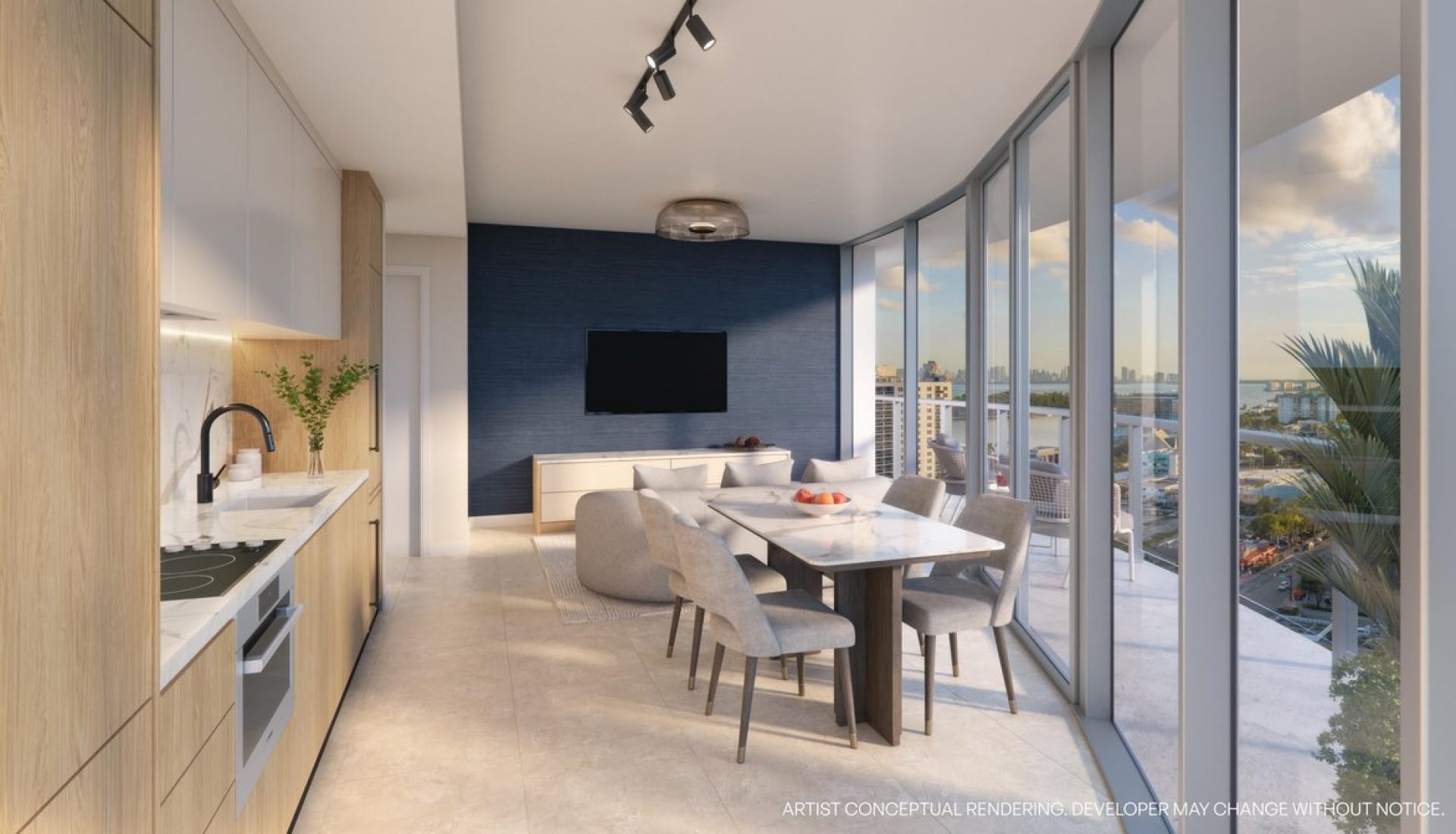 Open-concept living area with a light wood kitchen, marble counters, a rectangular dining table, and a blue feature wall with a TV on it. (Informative)