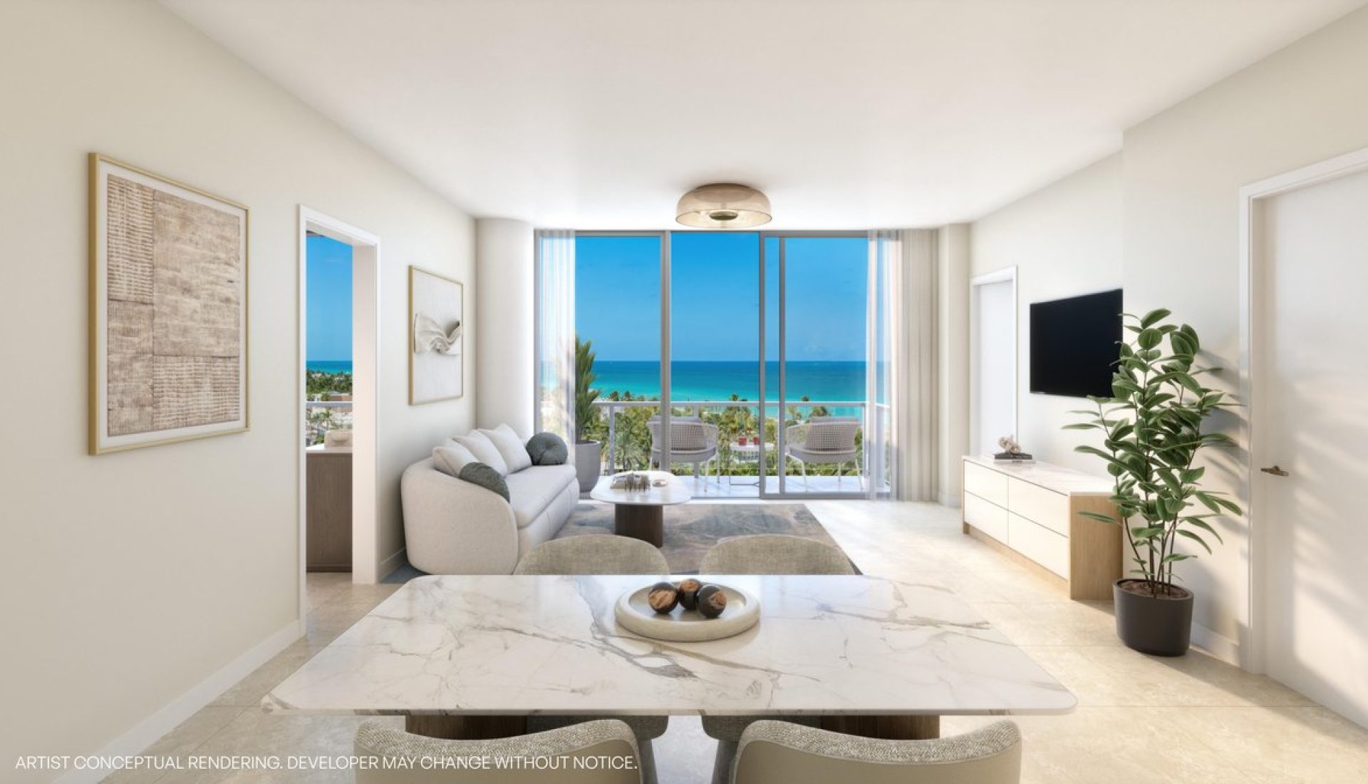 Modern open-concept living room with marble dining table in foreground and a seating area; glass balcony doors reveal an ocean view and palm trees outside.
