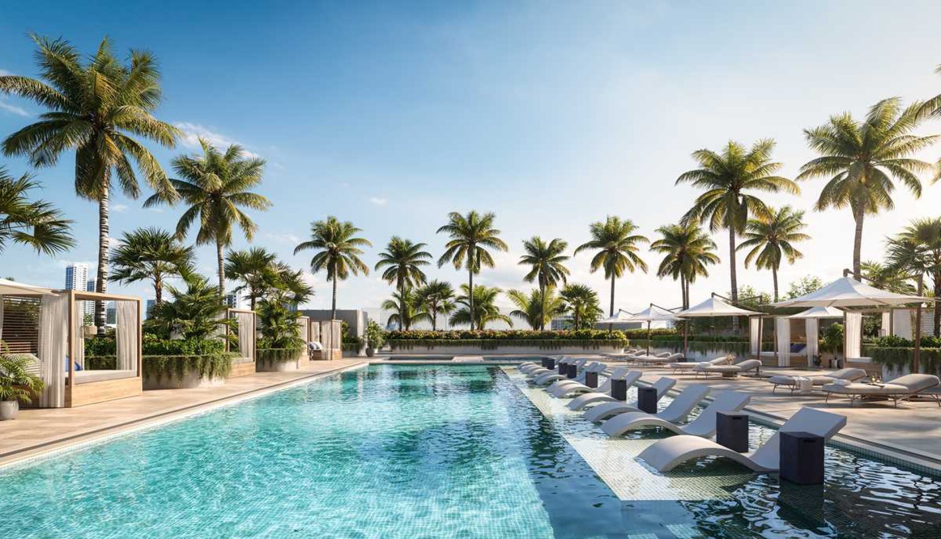 Resort pool lined with palm trees, white lounge chairs, and cabanas under a clear blue sky.