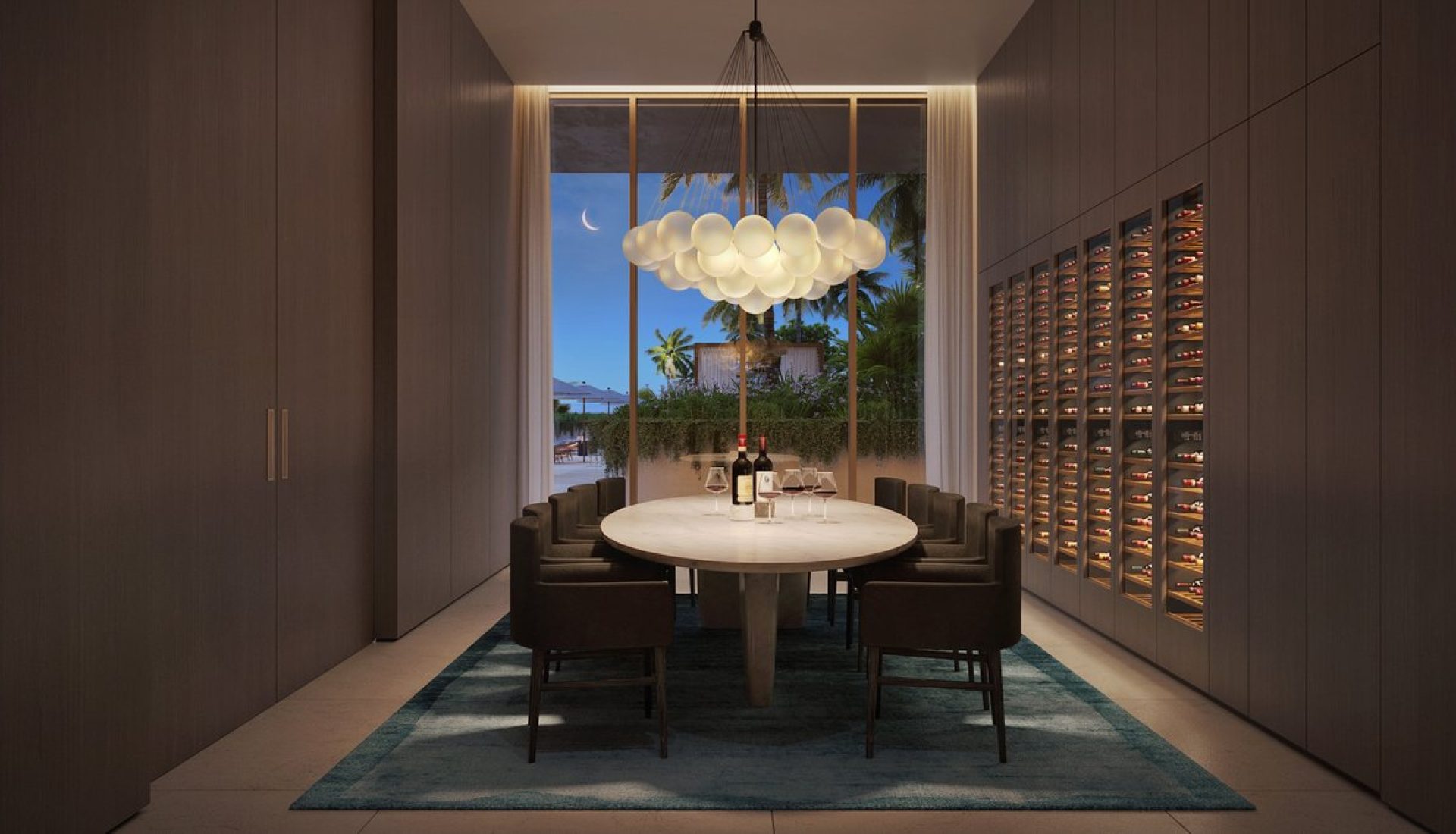 Luxurious dining room with a round marble table, brown chairs, globe chandelier, and a wine wall; night outside.