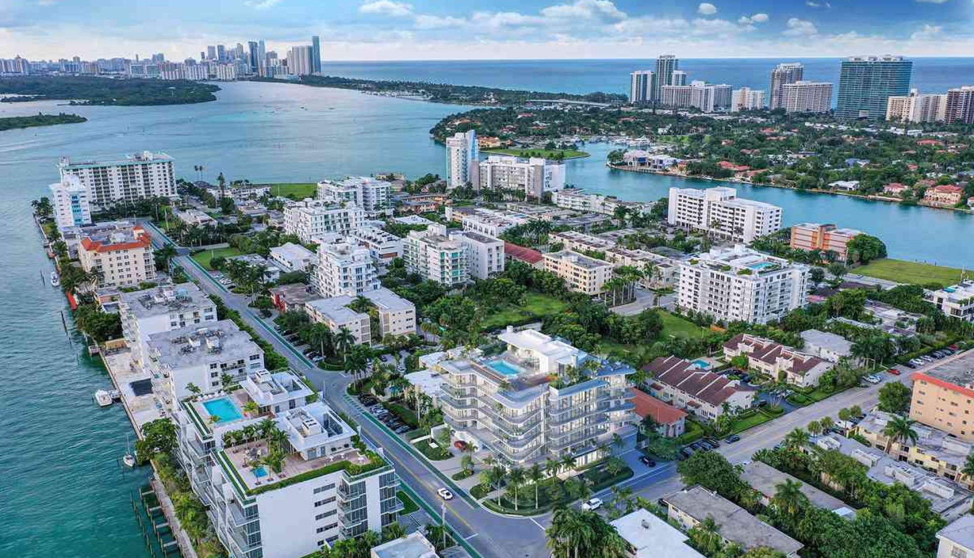 Aerial view of a coastal city with white apartment buildings along blue water and canals. (informative)