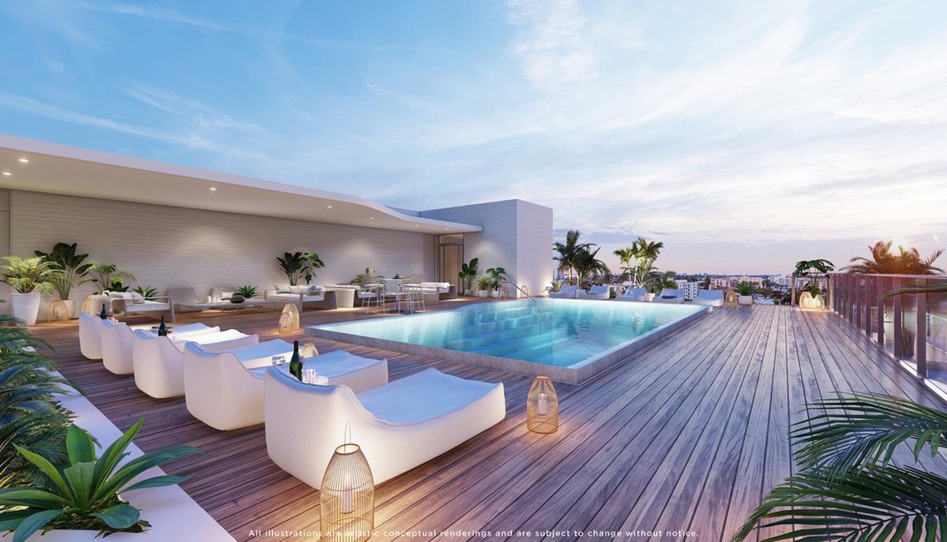 Rooftop pool deck with white lounge chairs, lanterns, and plants overlooking a city skyline at sunset.