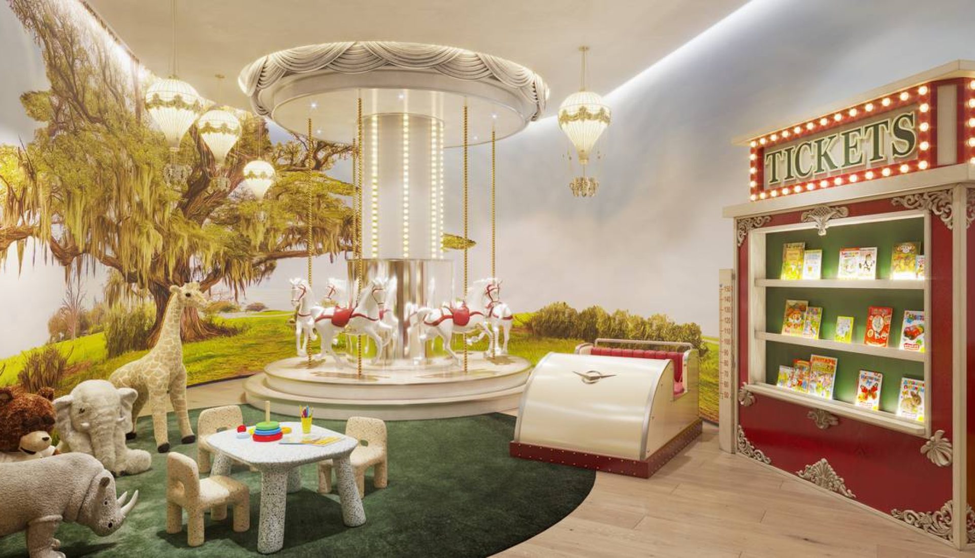 Whimsical indoor children's play area with a small carousel, plush animals, and a toy table, near a bright “Tickets” display shelf.