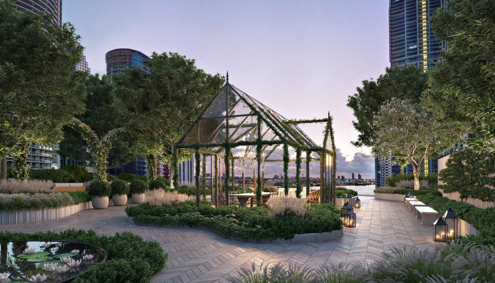 Rooftop garden with a glass-framed pergola, seating, lanterns, and planters, overlooking the city skyline at dusk.
