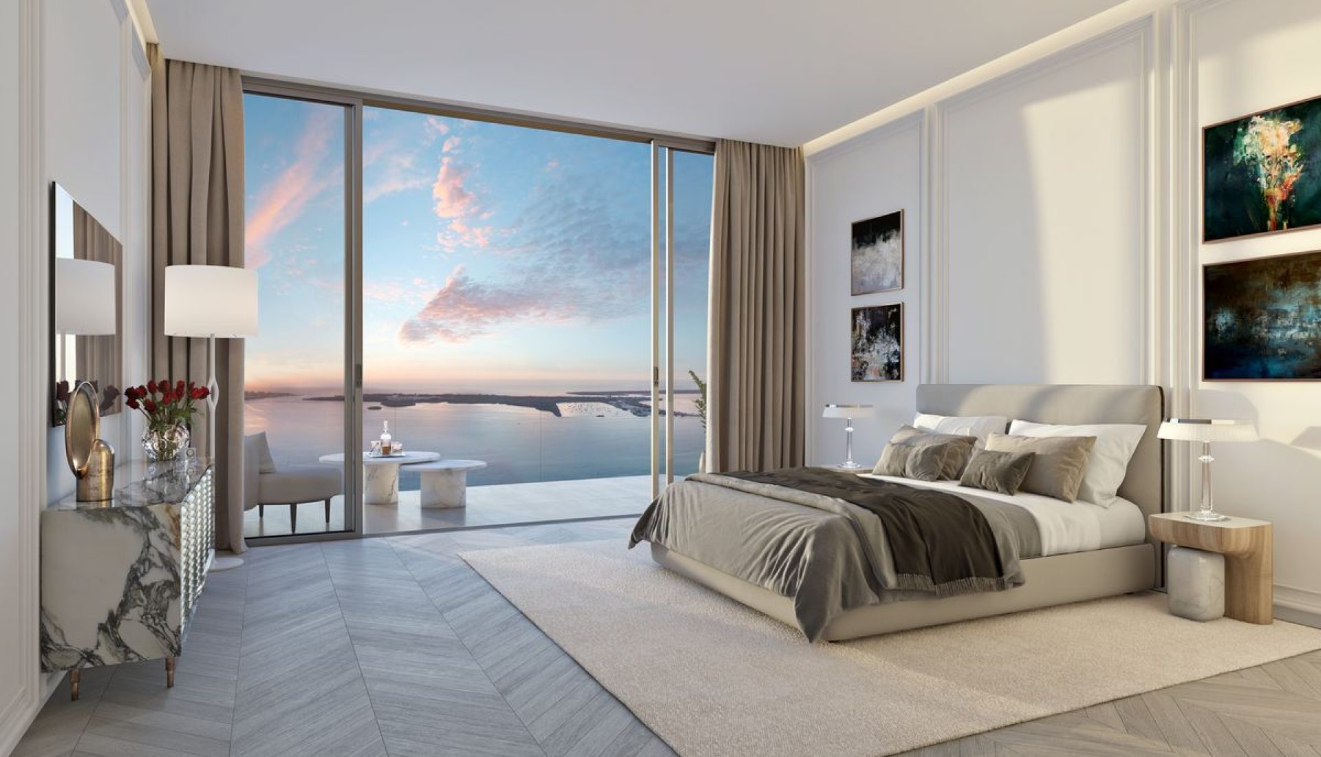 Luxurious bedroom with a king bed, neutral palette, and a glass balcony overlooking a sunset over the sea.