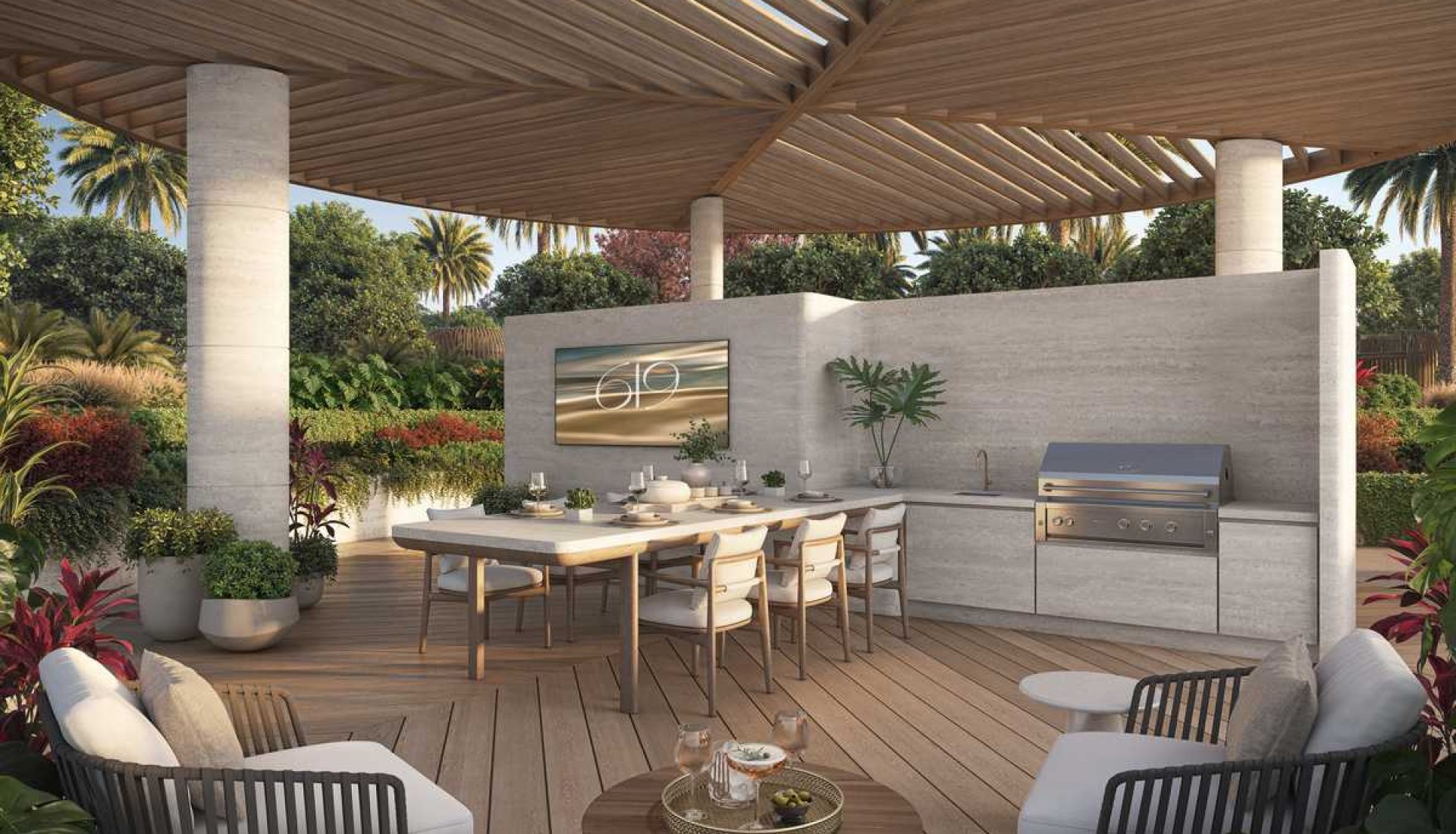 Outdoor kitchen and dining area under a wooden pergola, with a long table, built-in grill, and lounge seating among tropical plants.
