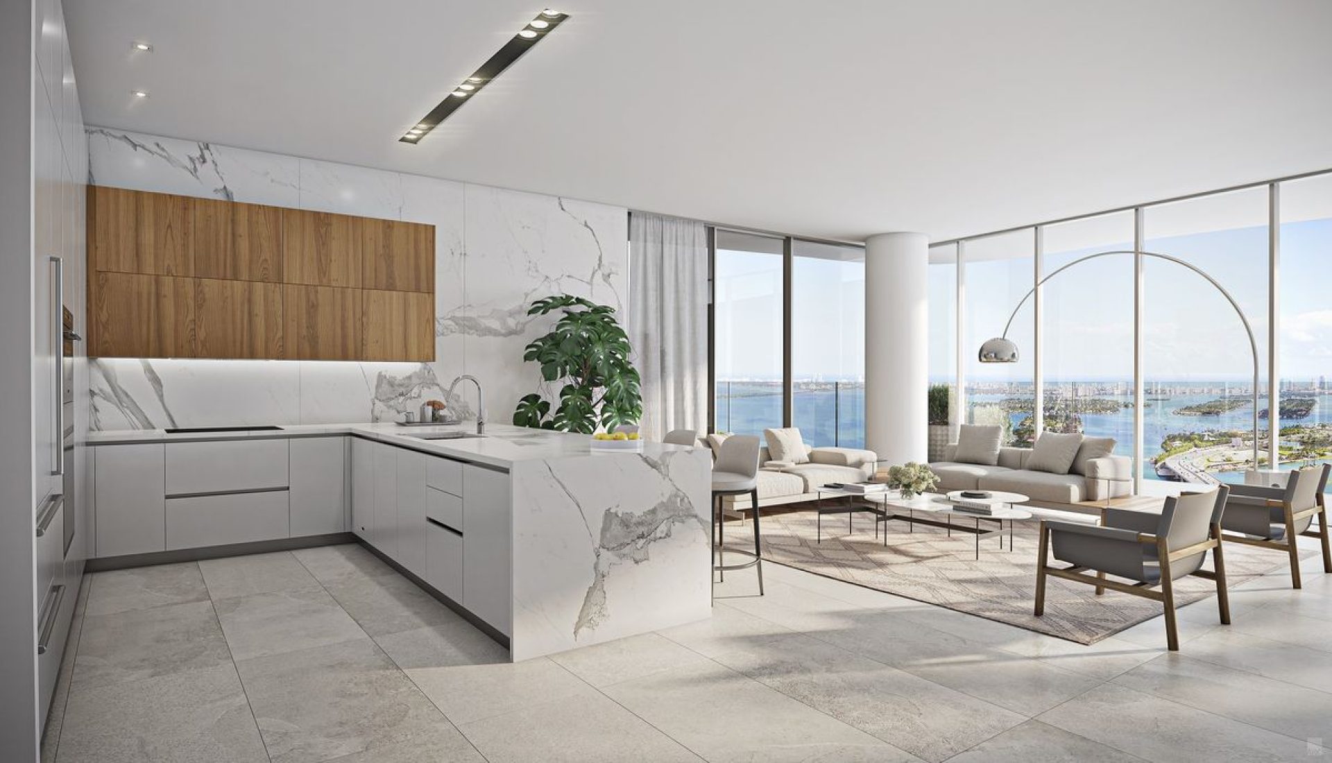 Open-concept kitchen with white marble island and waterfall counters, wood wall cabinets, and a living area with neutral furniture and a floor-to-ceiling window view of the sea.