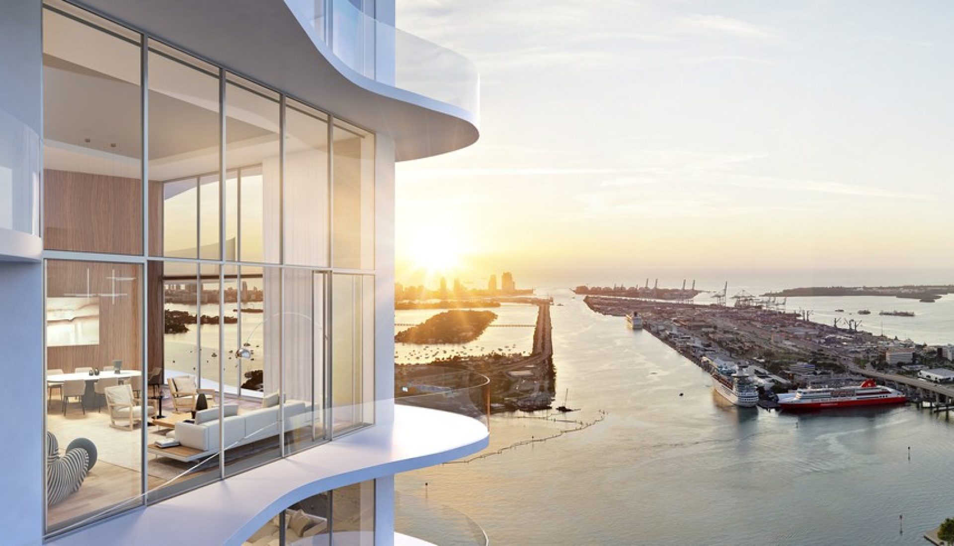 Modern glass-walled living area with a sunset over a marina and ships beyond.