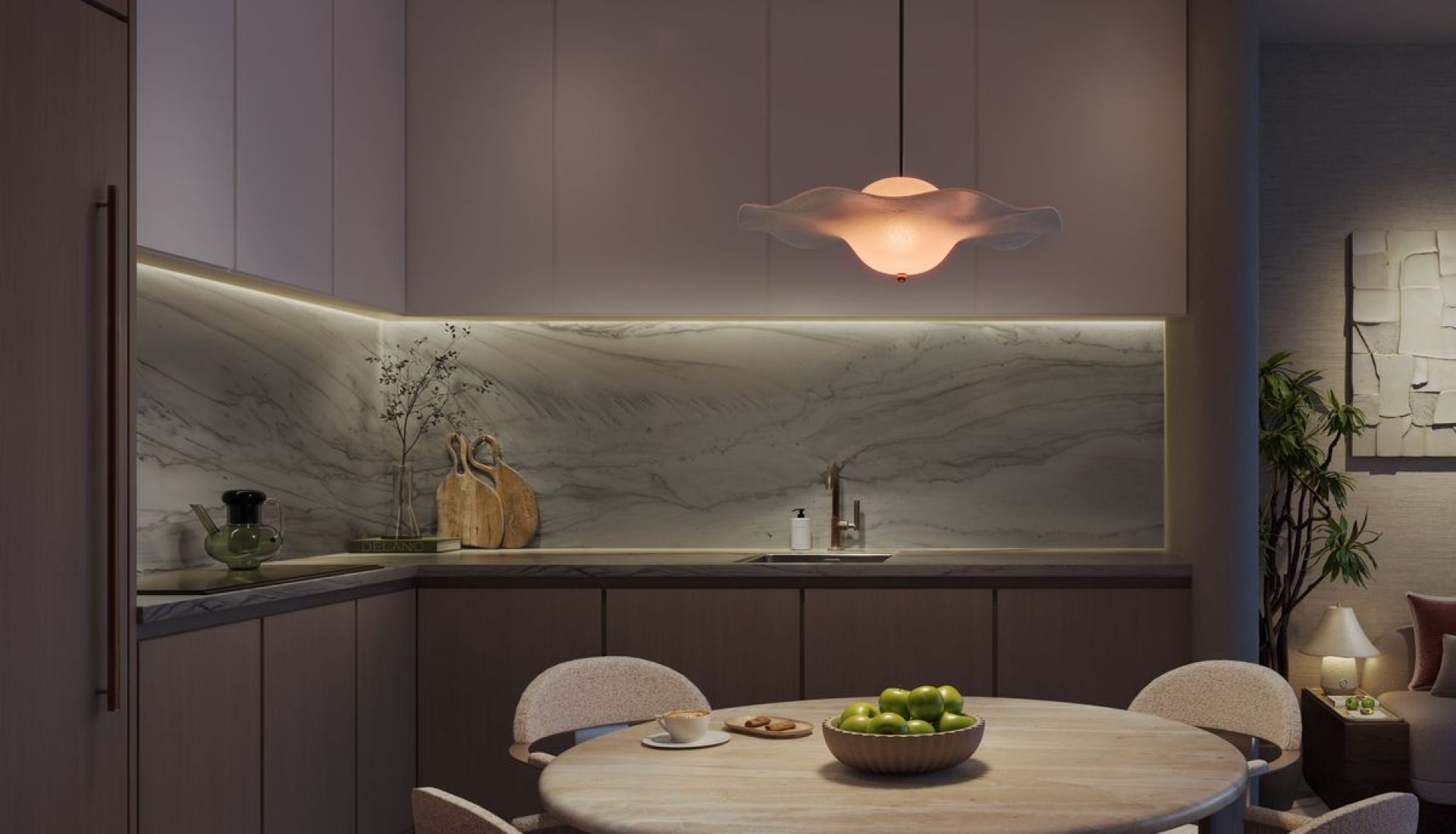 Modern kitchen with marble backsplash, recessed cabinets, and a round dining table with upholstered chairs; Delano branding visible in the corner.