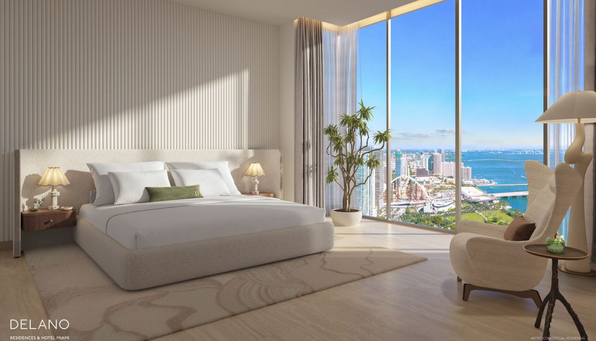 Luxurious hotel bedroom with a king bed, matching nightstands, and a beige rug, bathed in natural light from floor-to-ceiling windows overlooking the city and water.