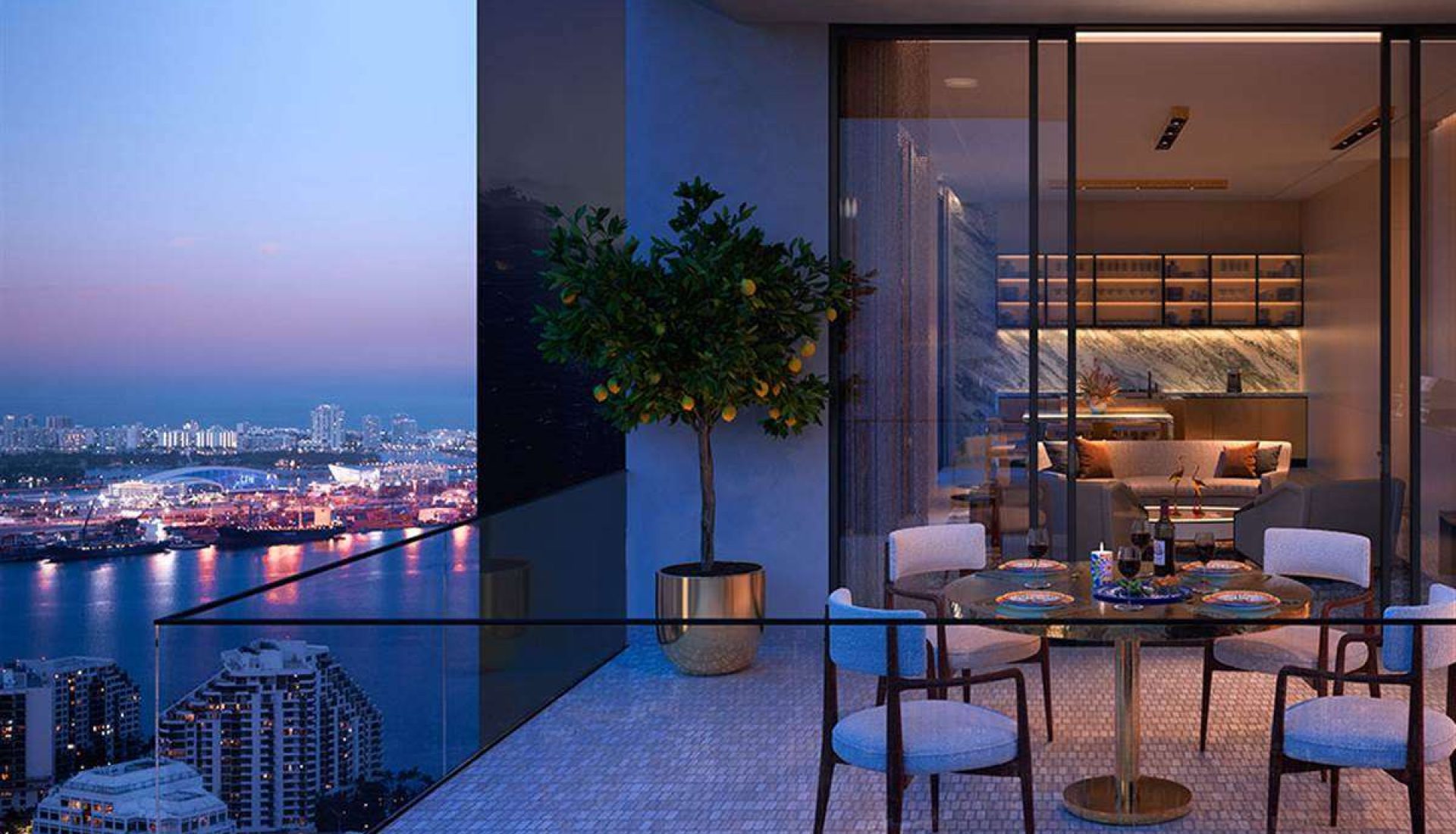 High-rise balcony dining area at dusk with a round glass table set for four, a potted citrus tree, and a city skyline view beyond.