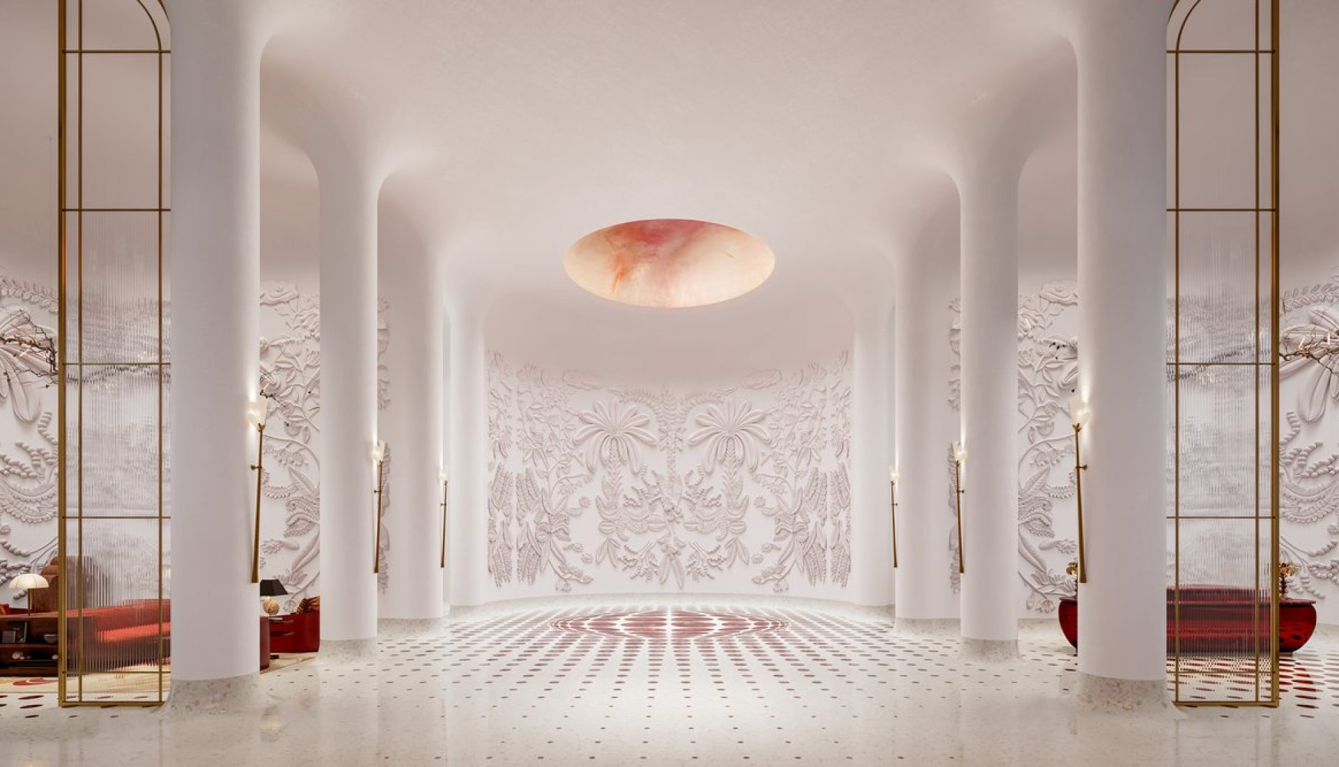 Elegant white lobby with tall arches, slender columns, intricate wall reliefs, and a circular peach-toned ceiling light.