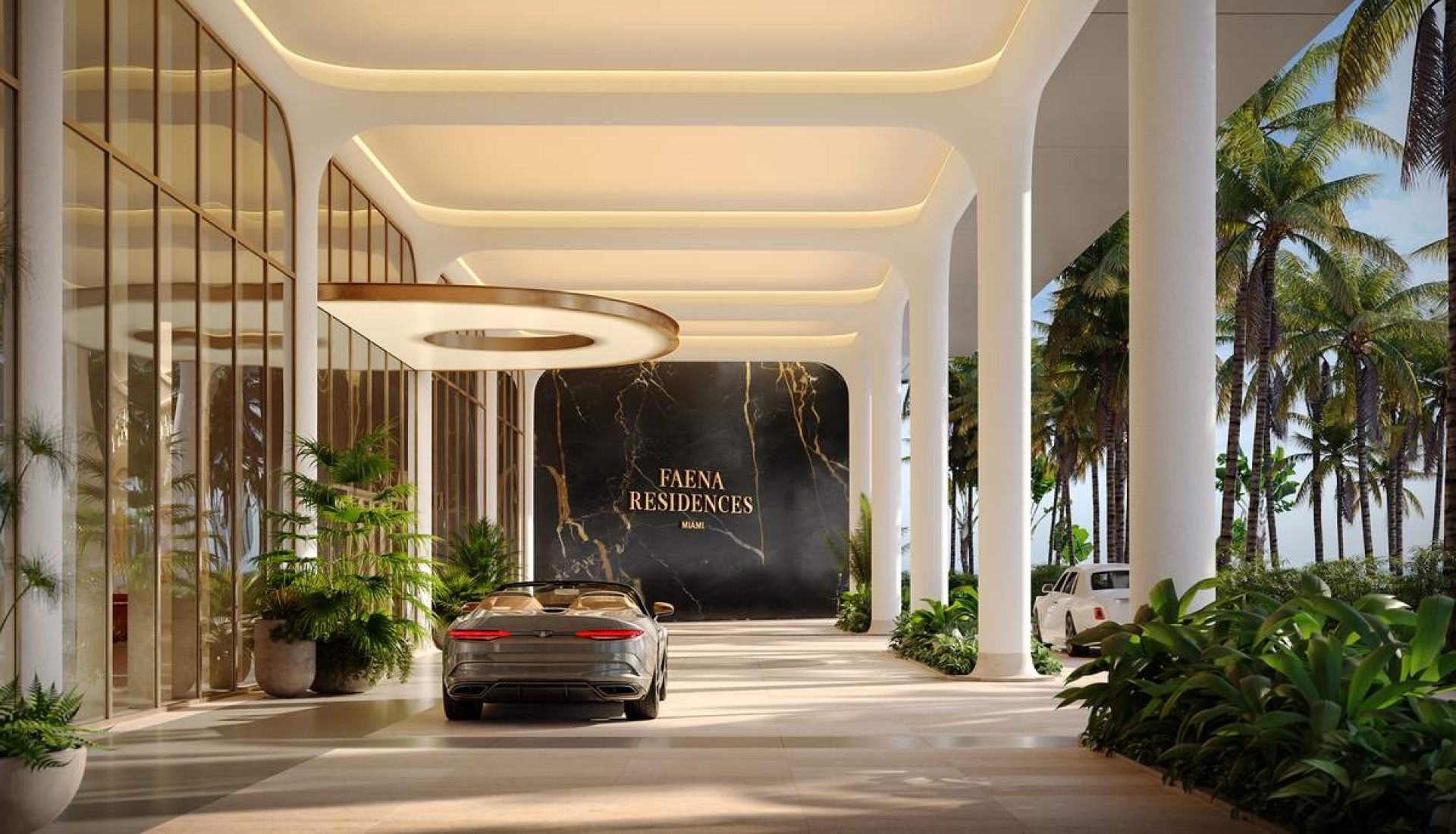 Entrance to Faena Residences Miami with a silver luxury car under a white, curved portico and glass walls, tropical plants nearby.