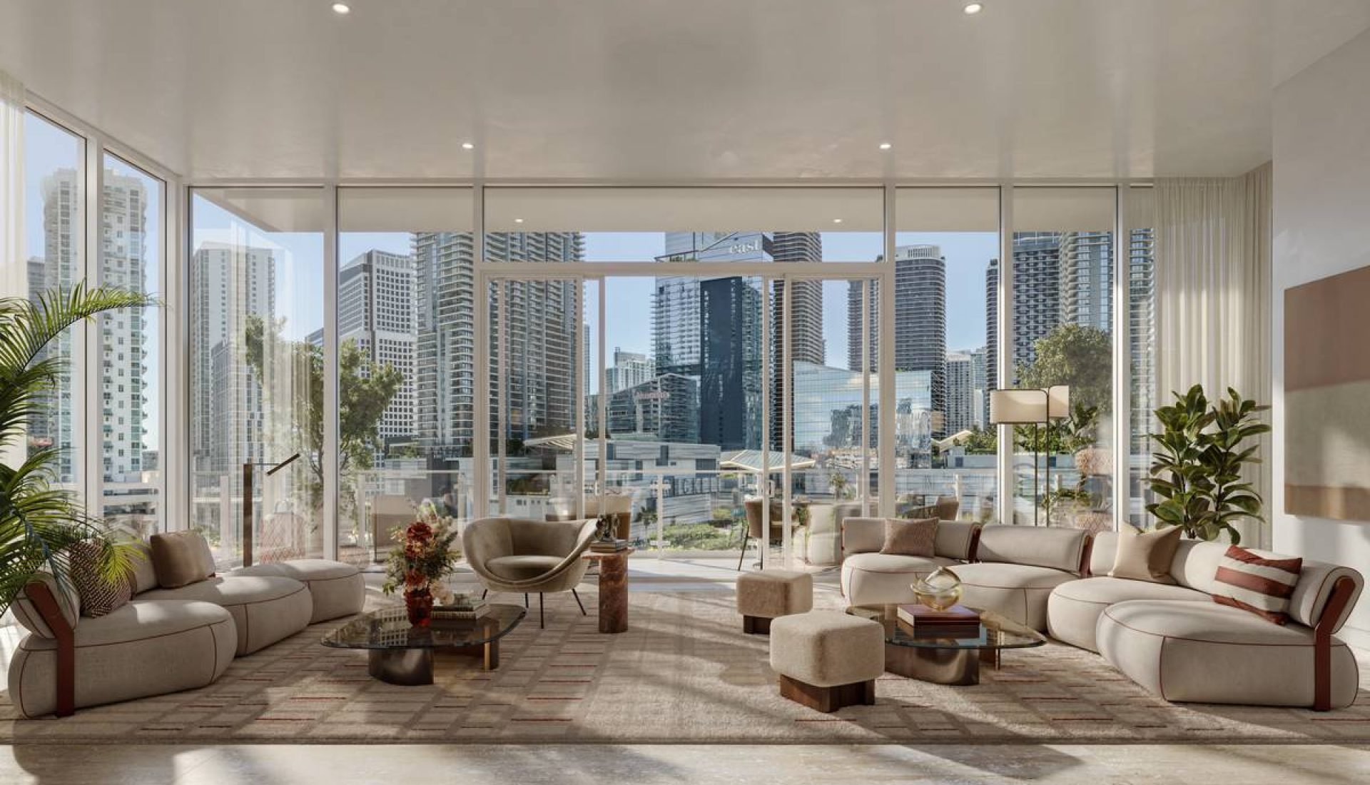 Spacious modern living room with curved beige sofas, glass coffee tables, and floor-to-ceiling windows overlooking a city skyline, bright and airy.