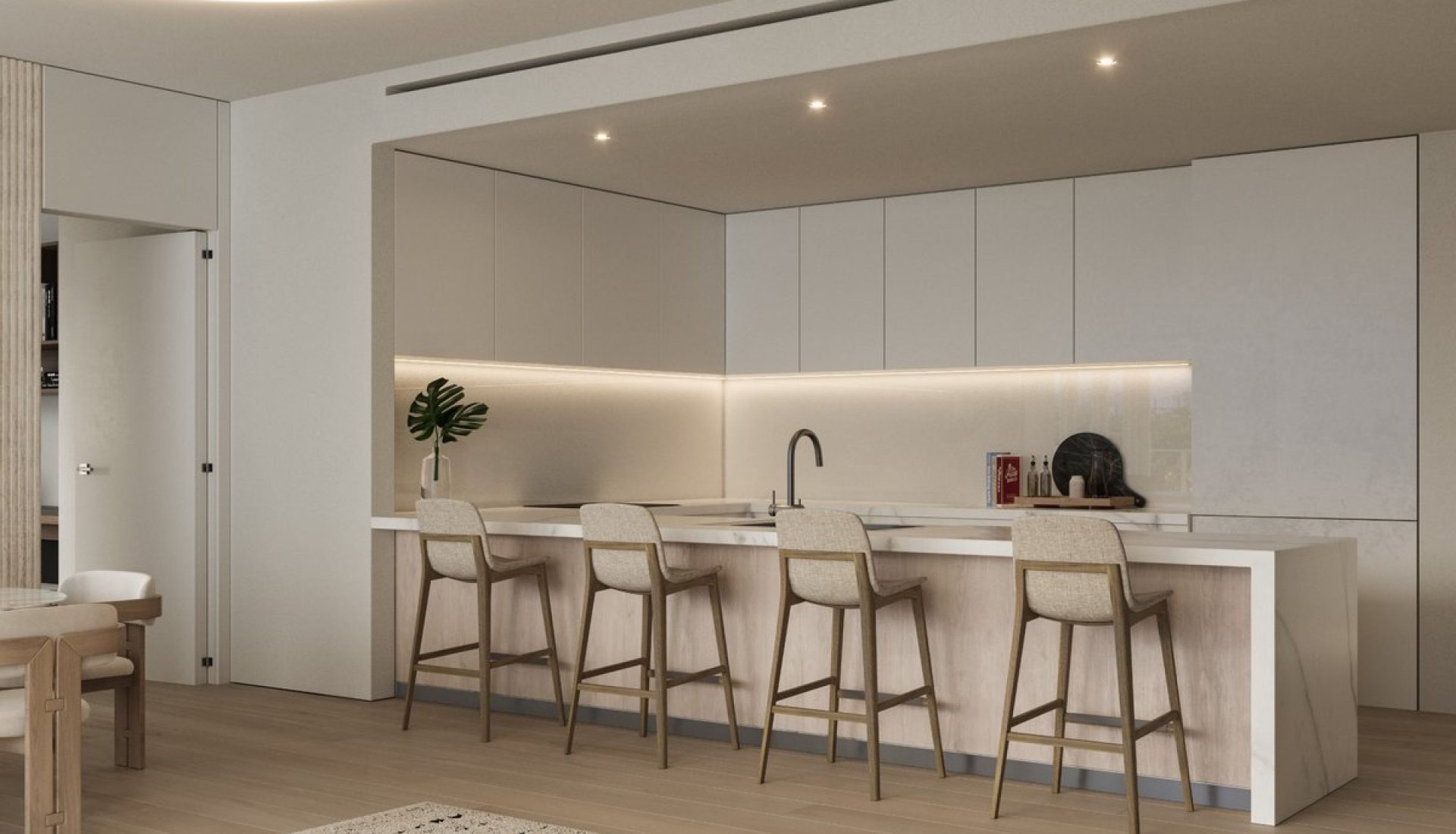 Modern open-plan kitchen with a long marble island, white cabinetry, and four beige bar stools under soft under-cabinet lighting.