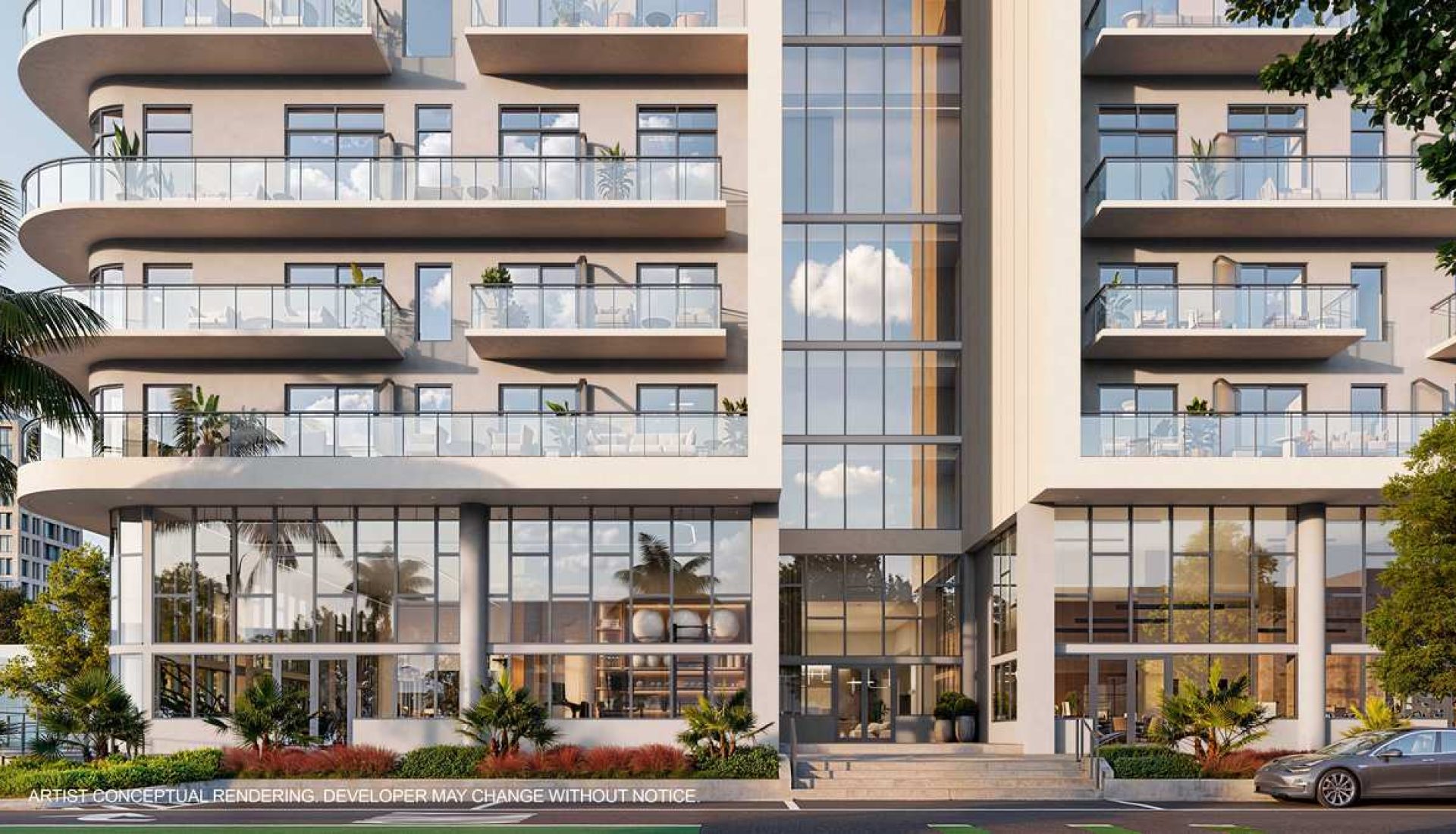 Modern, multi-story apartment building with curved balconies and large glass storefronts at ground level.