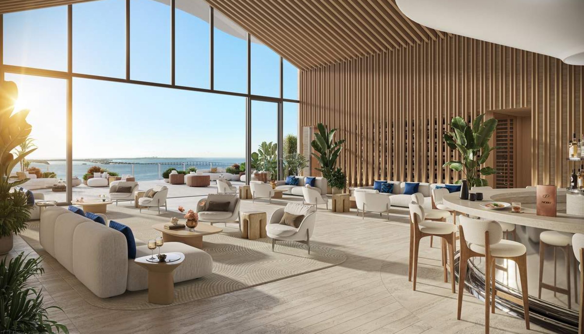 Luxurious seaside lounge with floor-to-ceiling windows, sunlit beige seating, and a bar area by the shore.