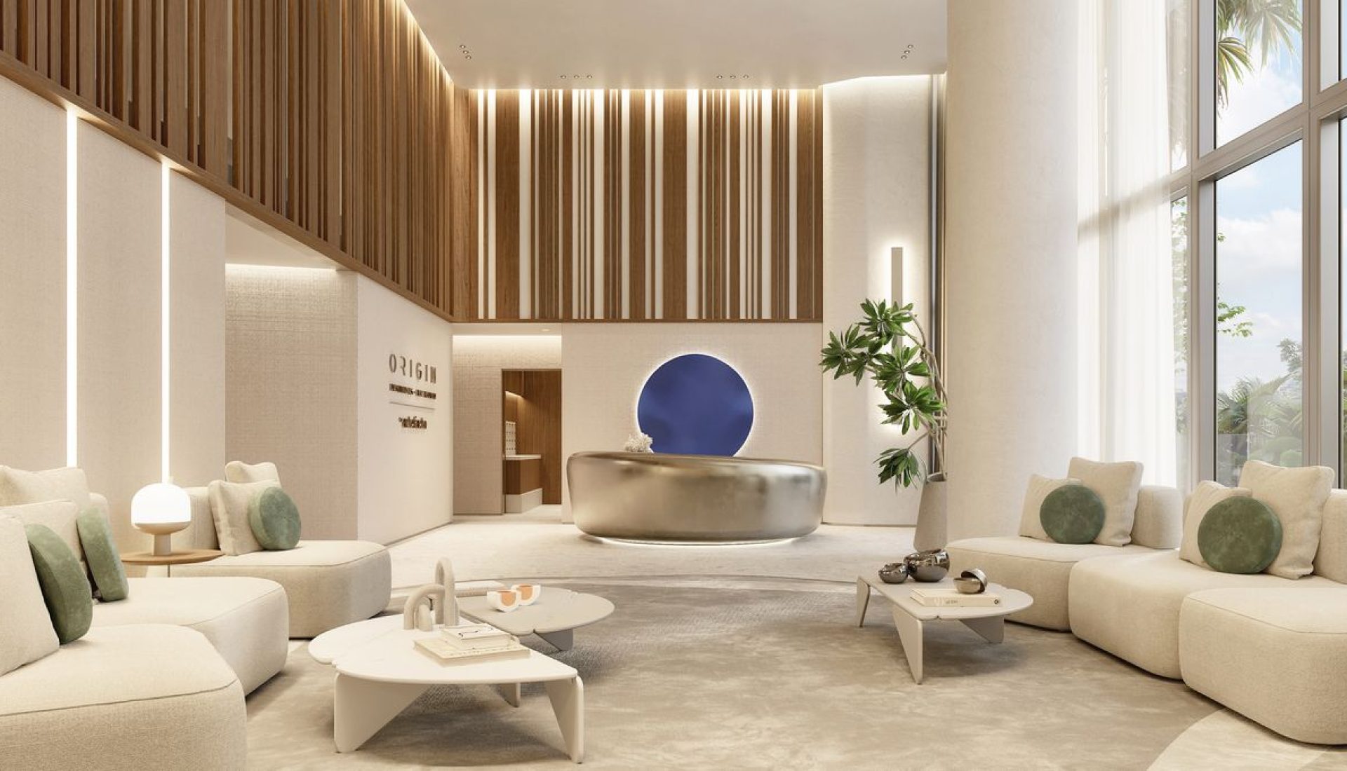 Luxurious hotel lobby with beige curved sofas, a metallic round reception desk, and a blue circular wall art.