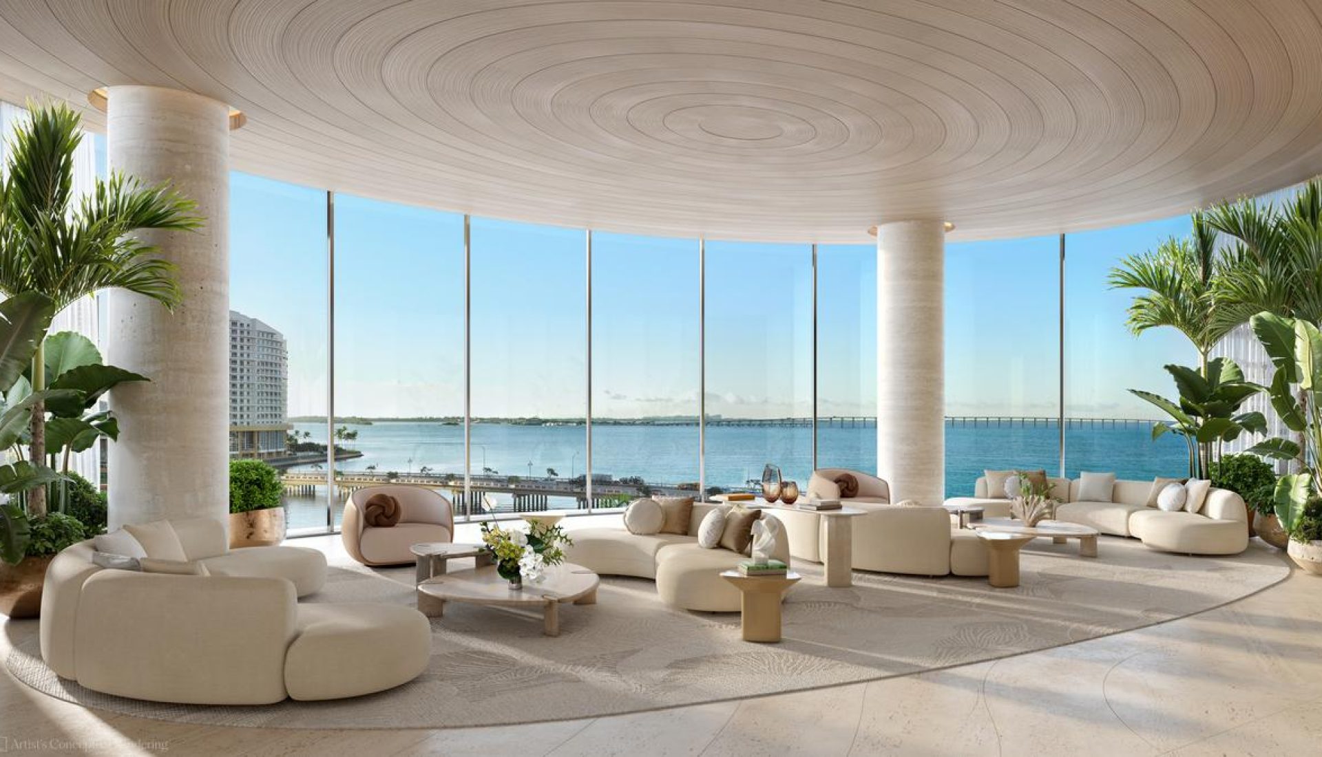 Luxurious beige lounge with circular sofas and panoramic ocean view through floor-to-ceiling windows.