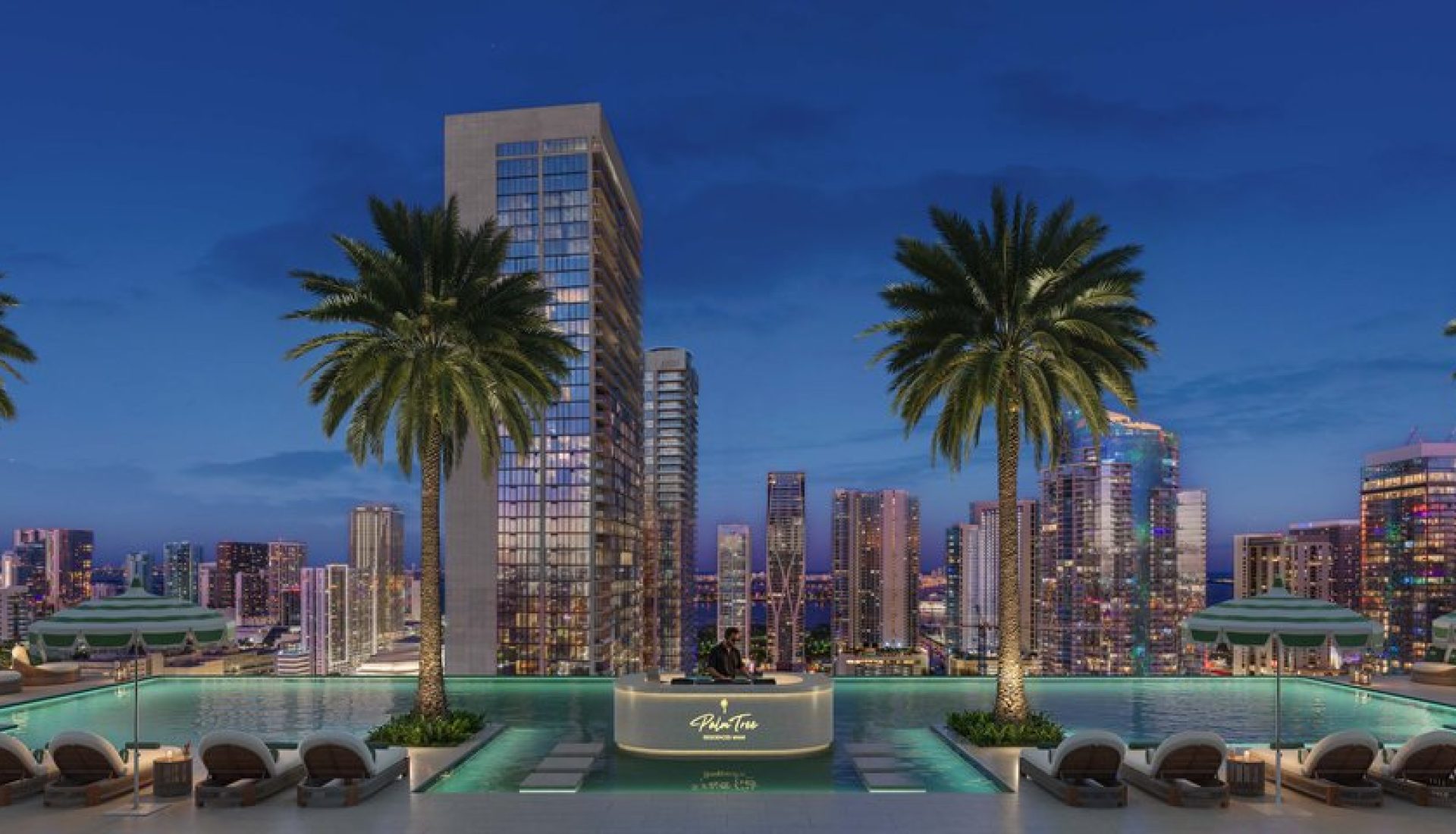 Rooftop pool at dusk with palm trees framing a city skyline, lounge chairs, and a central DJ booth by the pool edge.
