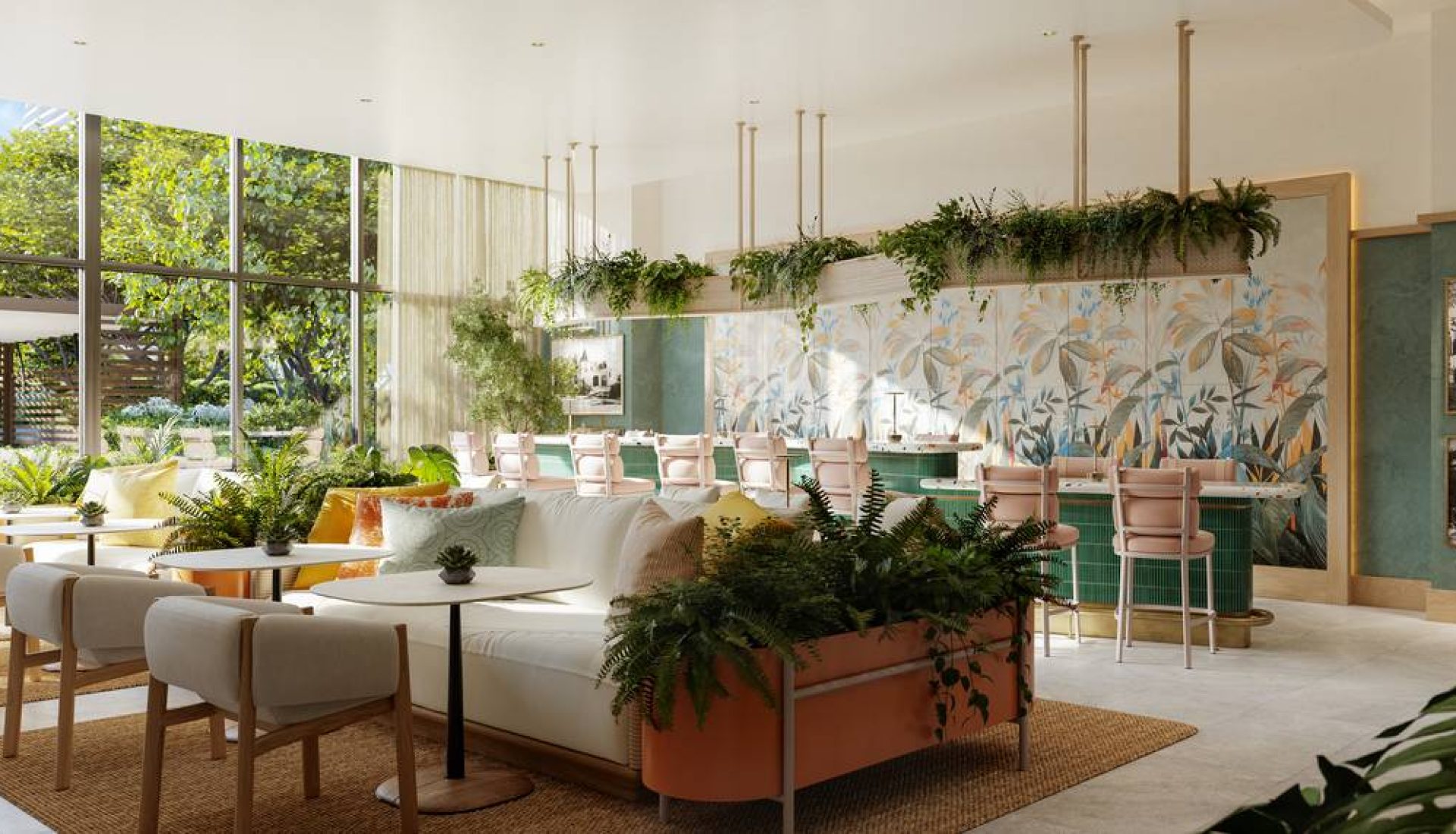 Bright, modern lounge with white sofas, pastel pink chairs, and abundant greenery by a glass wall of windows.