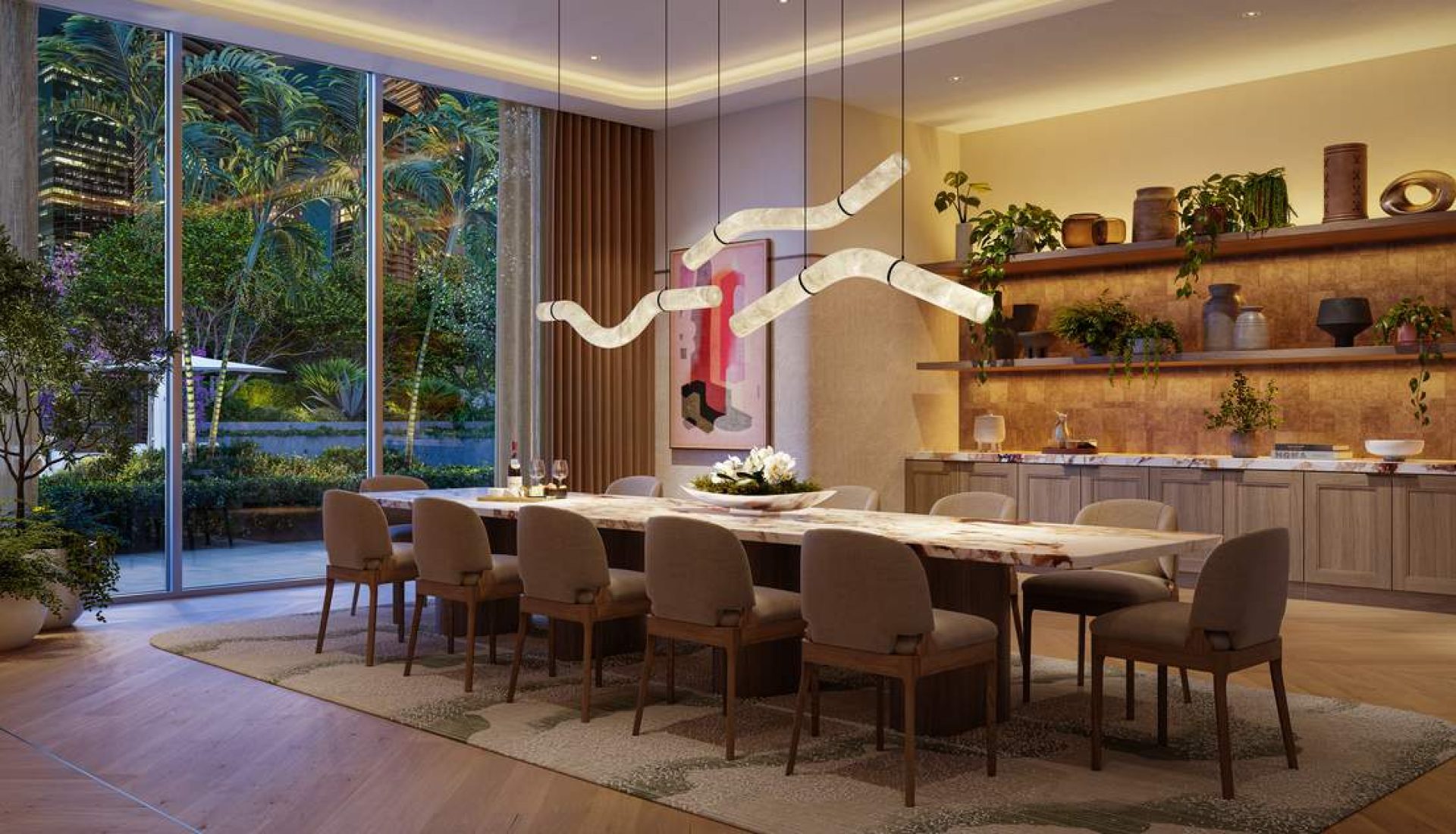 Long marble dining table with beige upholstered chairs, sculptural pendant lights, and a garden view through large glass walls.