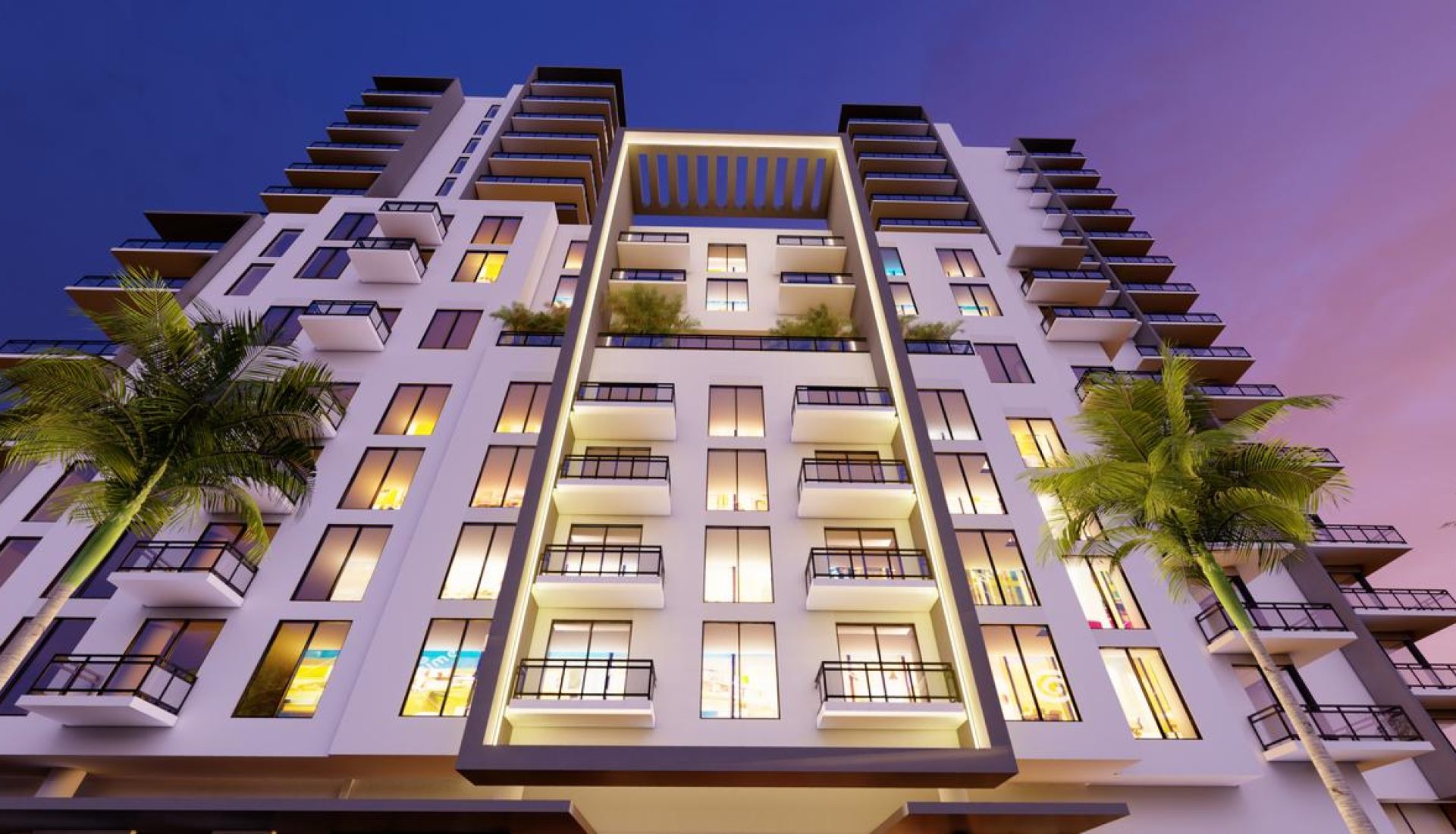 Modern high-rise apartment building at dusk with illuminated balconies and palm trees in front.