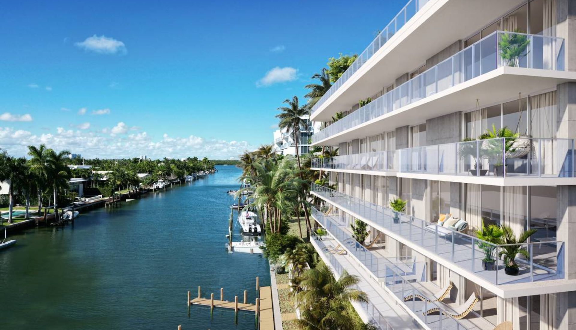 Modern waterfront apartment building with glass balconies overlooking a canal lined with palm trees and moored boats on a sunny day.
