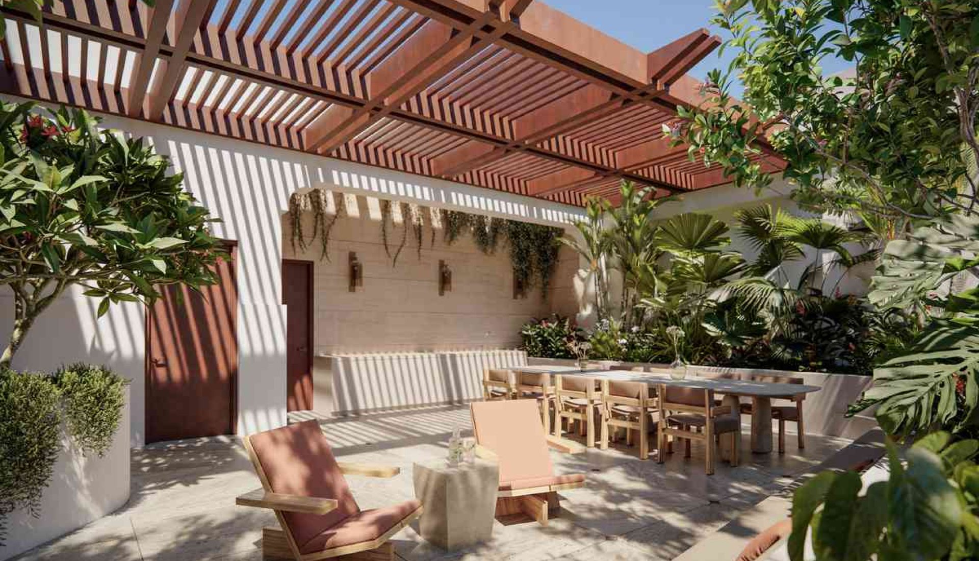 Outdoor courtyard with a long wooden dining table and chairs under a slatted wooden pergola, surrounded by lush greenery and dappled shadows.