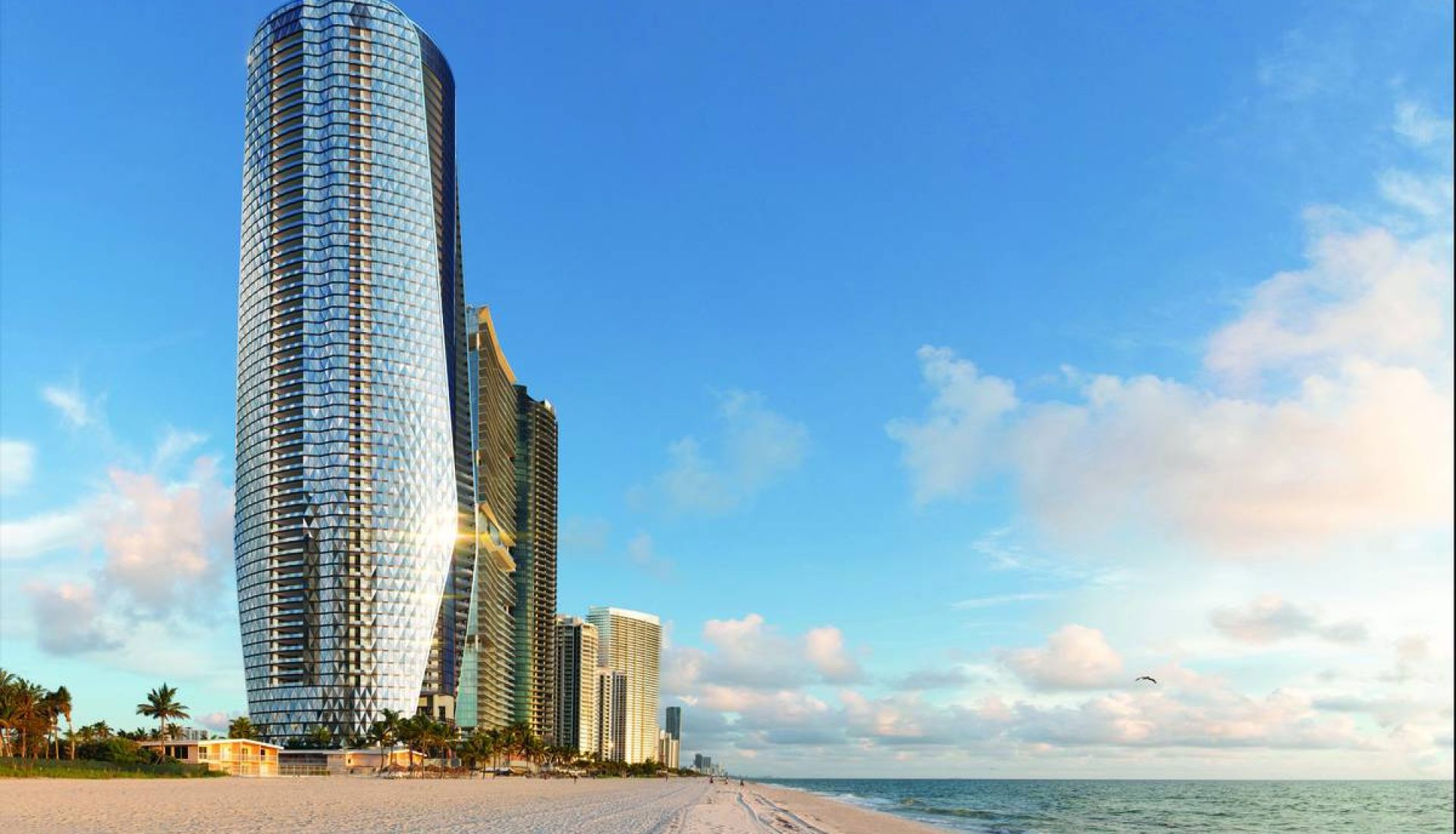 Curved glass skyscraper on a sandy beach with palm trees and the ocean under a blue sky.