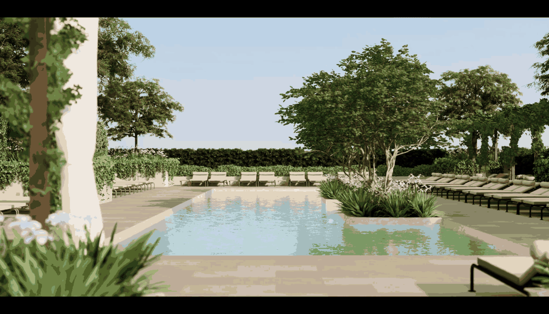 Poolside luxury scene with a long rectangular pool, row of lounge chairs, and lush trees under a clear blue sky.