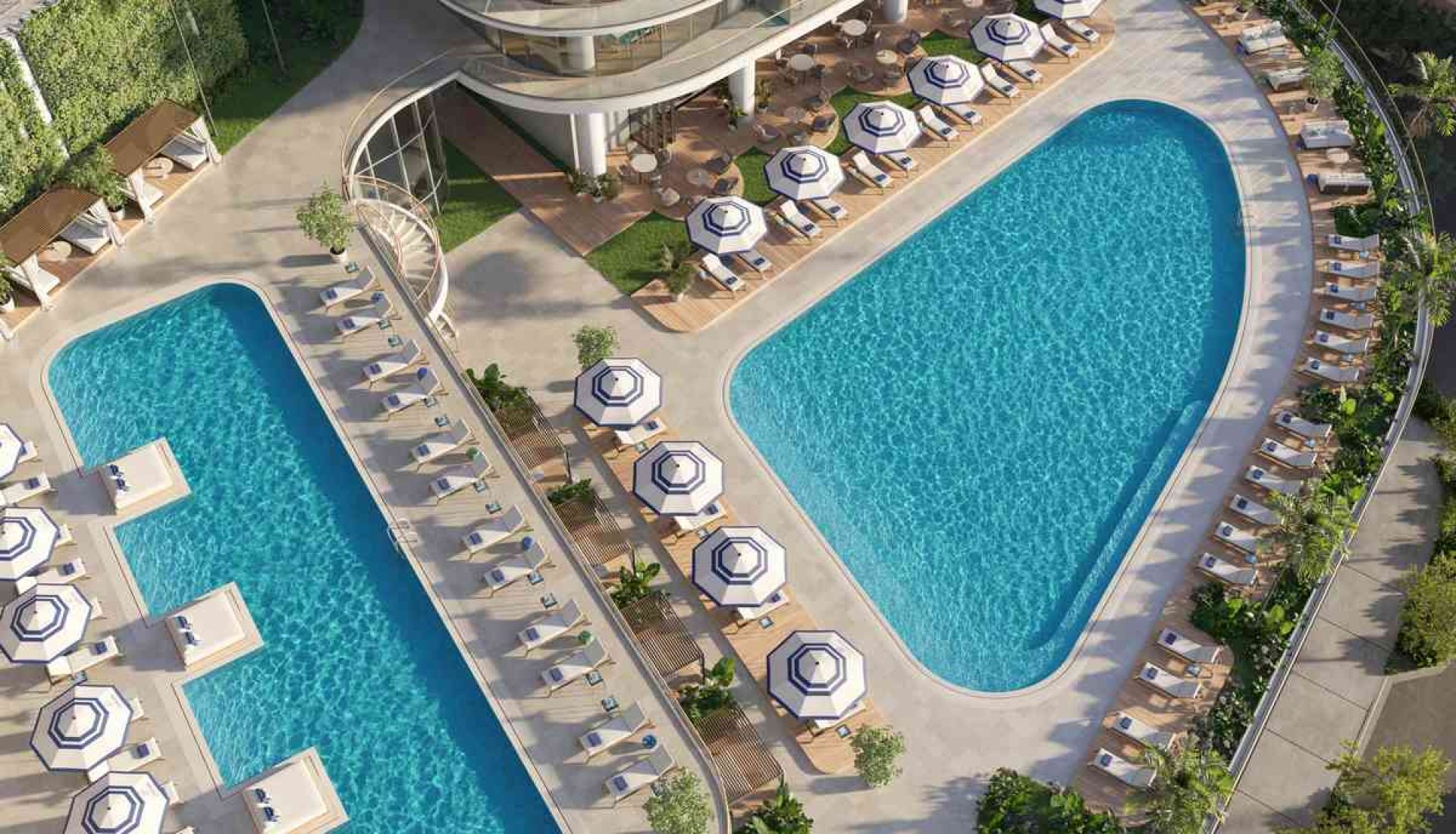 Aerial view of a resort pool deck with a curved main pool, a smaller adjacent pool, and rows of sun loungers with blue umbrellas.