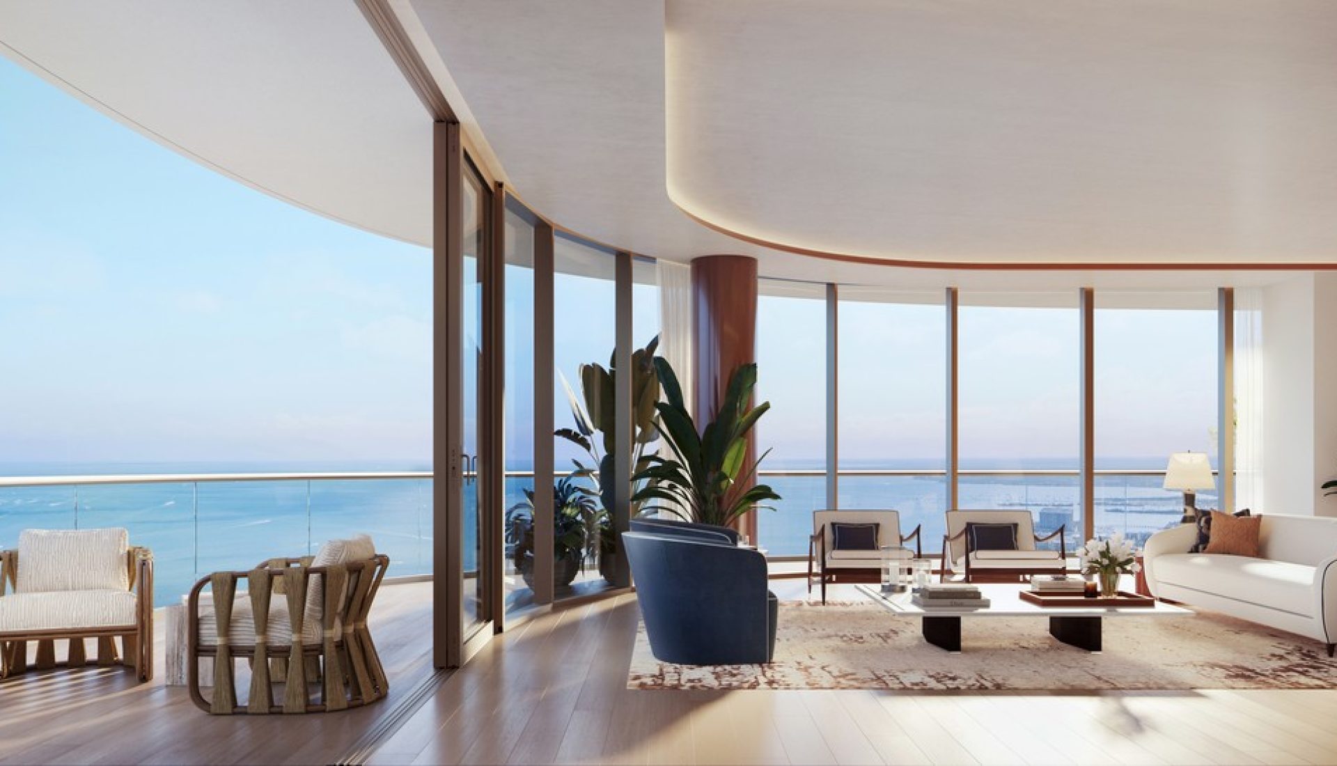 Luxurious beachfront living room with floor-to-ceiling ocean views, white sofa, blue chairs, plants, and a central coffee table.