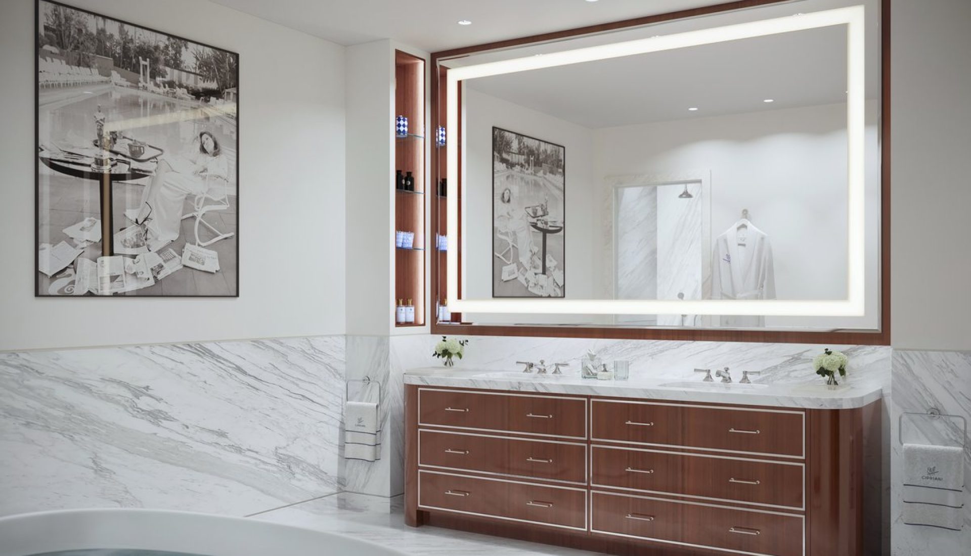 Luxurious bathroom with marble surfaces, a double sink vanity, and a backlit rectangular mirror.