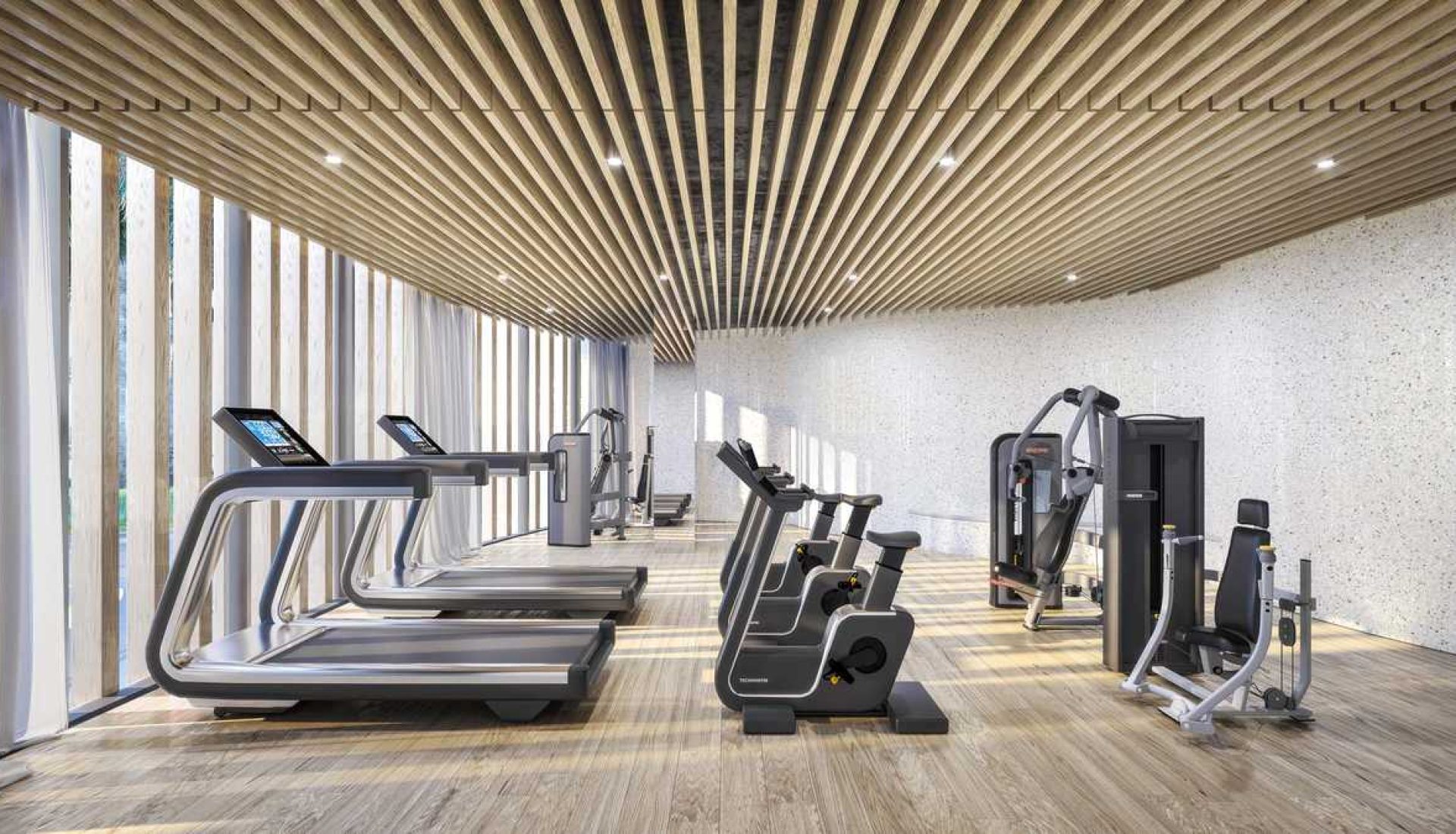 Modern gym interior with treadmills, stationary bikes, and weight machines on a wooden floor.